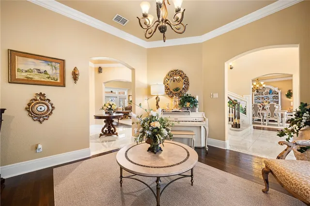 a living room with dining table and a chandelier