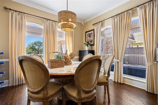 a dining room with furniture a chandelier and wooden floor