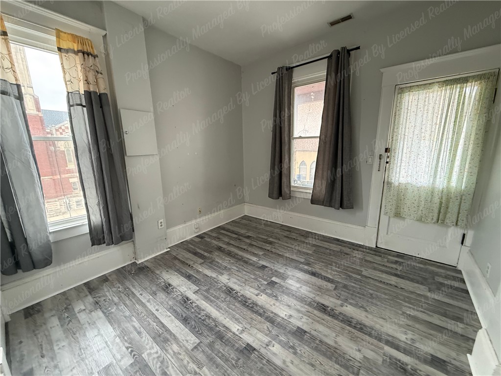 44 West High Street, Unit D Springfield, OH 45502 - Photo 18 of 25 This bright room features durable flooring and ample natural light, creating a versatile living space.