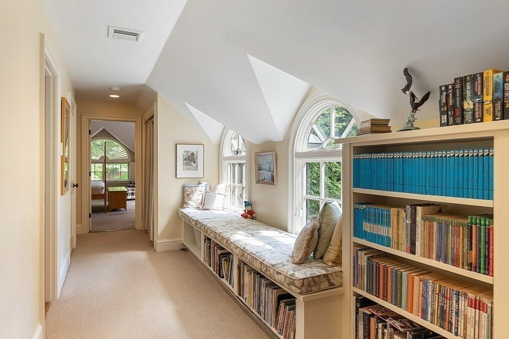 148 Monument Street Concord, MA 01742 - Photo 12 of 25 a living room with furniture a baby crib and a book shelf