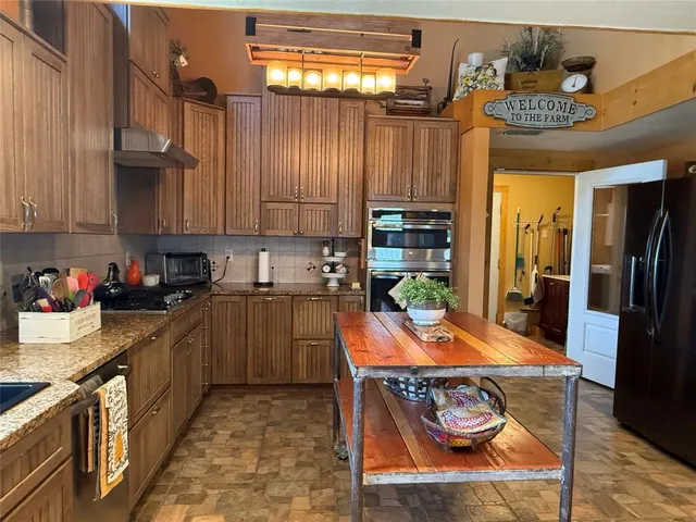 a kitchen with granite countertop a sink a counter top space and cabinets