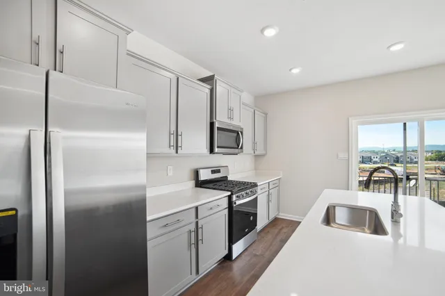 a kitchen with a sink stainless steel appliances and cabinets