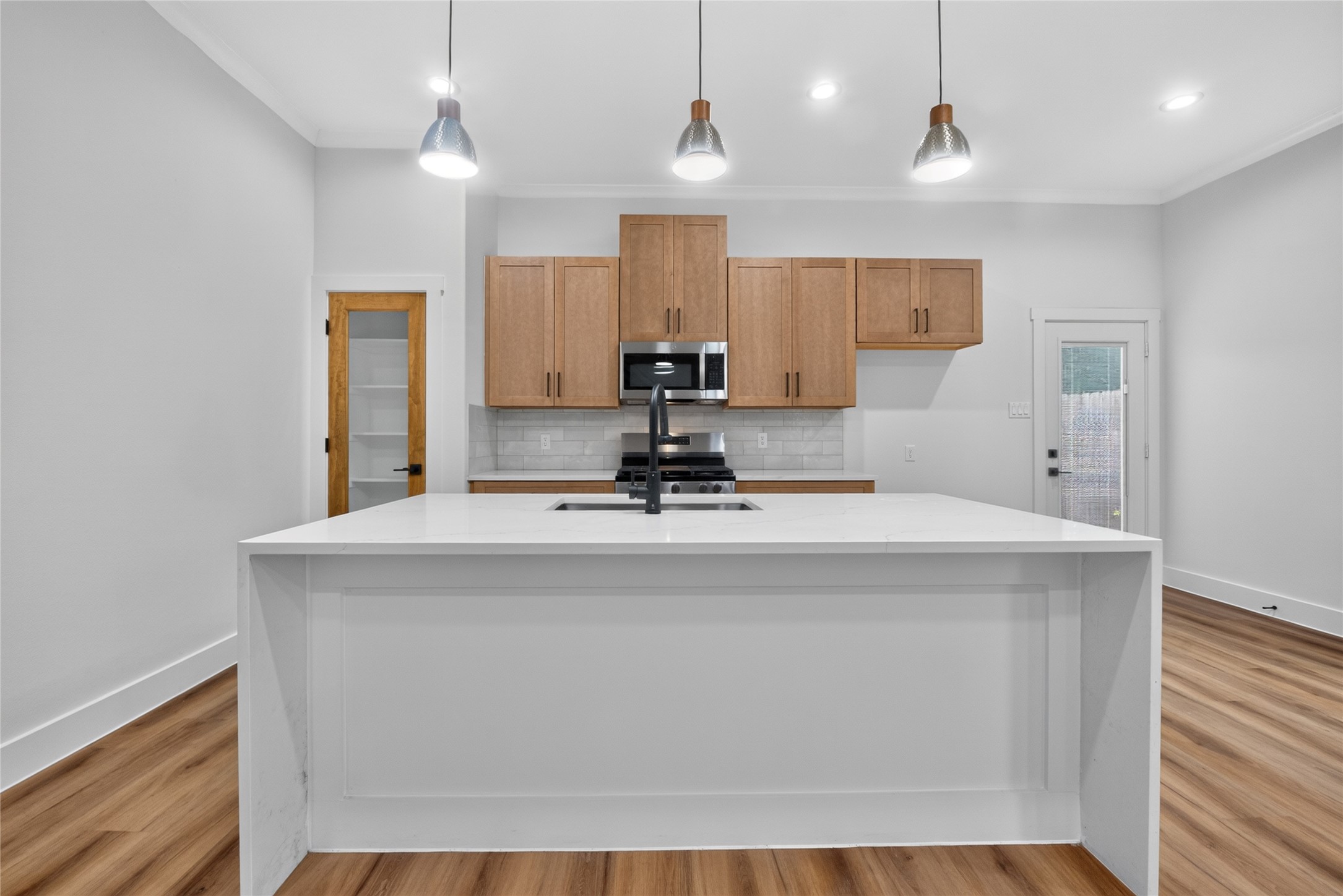 3537 Amos Street Houston, TX 77021 - Photo 15 of 32 A refined kitchen anchored by a generous island, sleek stainless-steel appliances, and a spacious pantry for effortless storage--modern and functional. Refrigerator to be installed.