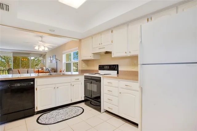 a kitchen with white cabinets a stove a sink and white cabinets
