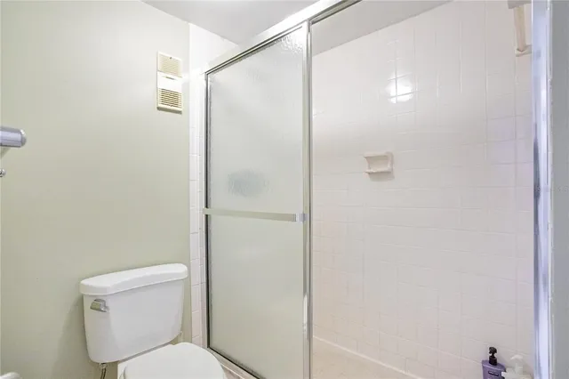 a white toilet sitting next to a shower