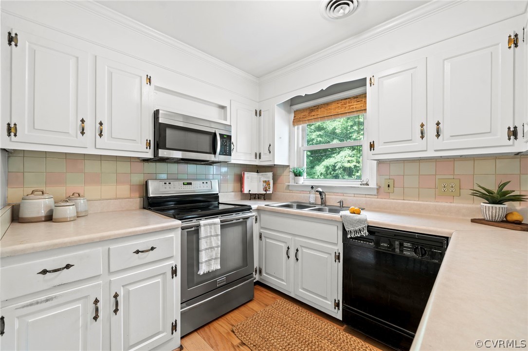 4001 Croatan Road Richmond, VA 23235 - Photo 7 of 25 a kitchen with stainless steel appliances granite countertop a sink dishwasher stove and white cabinets with wooden floor