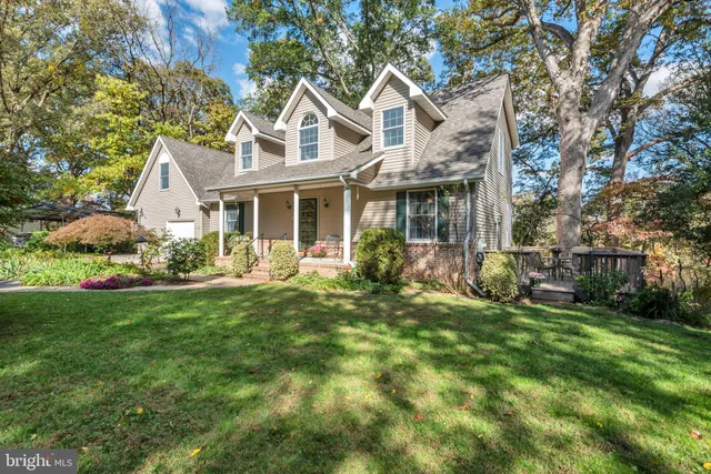 a front view of a house with a garden and trees