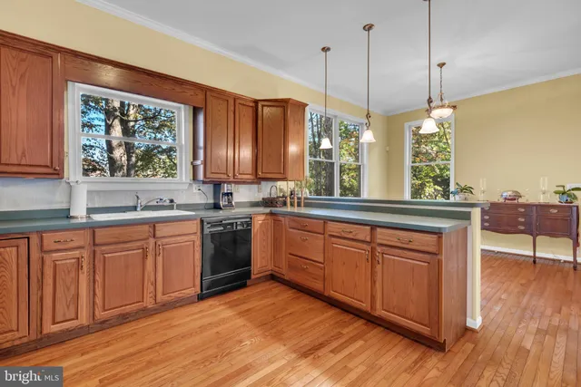 a kitchen with granite countertop wooden floors a stove and a refrigerator