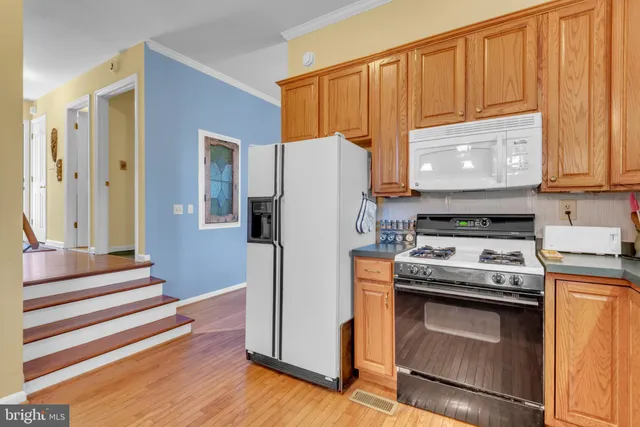 a kitchen with a table chairs refrigerator and a sink
