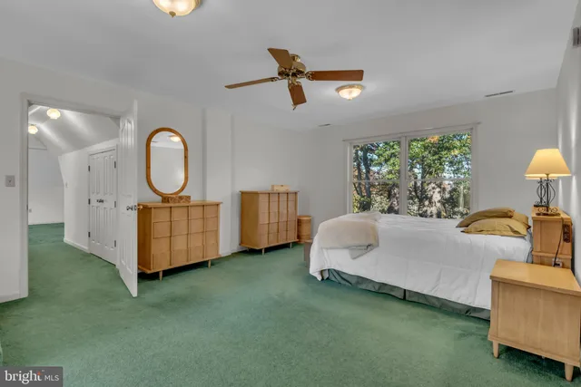 a view of an empty room with window and closet area