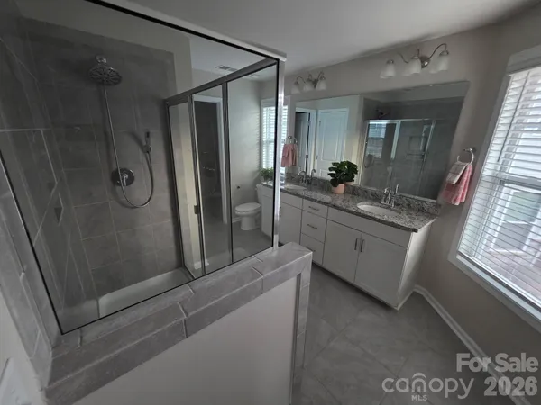 a bathroom with a granite countertop sink mirror and shower