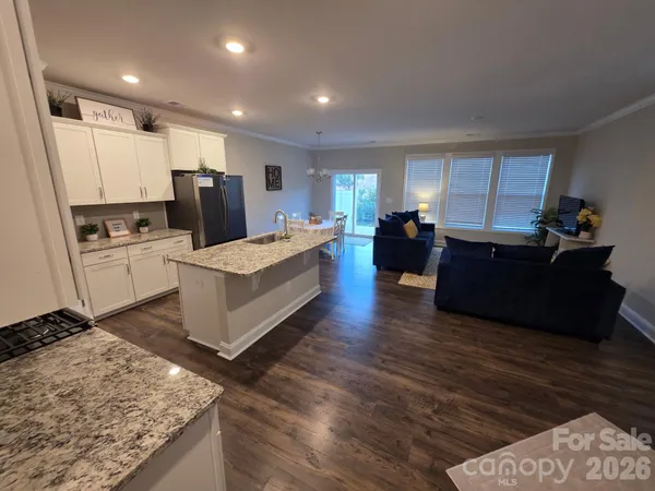 a large living room with stainless steel appliances granite countertop furniture a fireplace and a sink