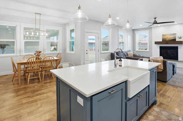 1009 High Creek Road Cove, UT 84320 - Photo 79 of 79 Kitchen featuring blue cabinetry, hanging light fixtures, light wood-type flooring, light stone counters, and open floor plan