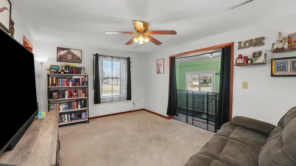 a living room with bookshelf and a window