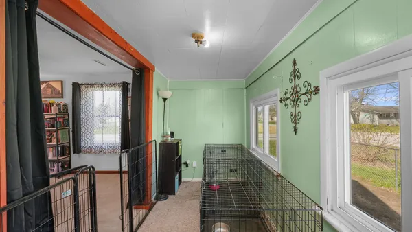 a view of a hallway with wooden floor and windows