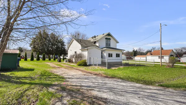 a front view of a house with a garden and yard