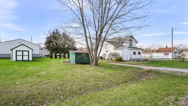 a view of a house with a big yard and large trees