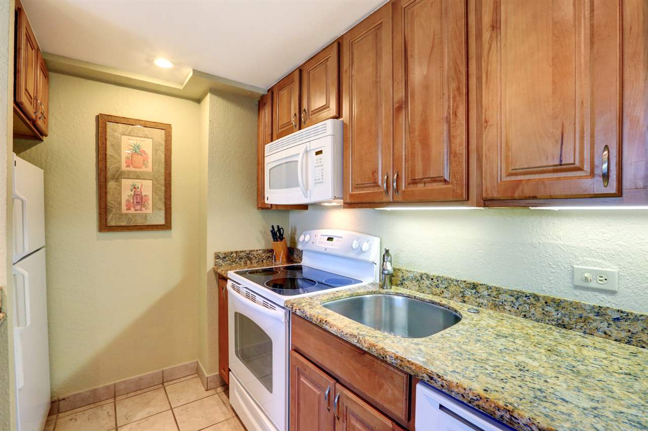 3445 Lower Honoapiilani Road, Unit 336 Lahaina, HI 96761 - Photo 15 of 22 a kitchen with granite countertop a sink a stove and cabinets