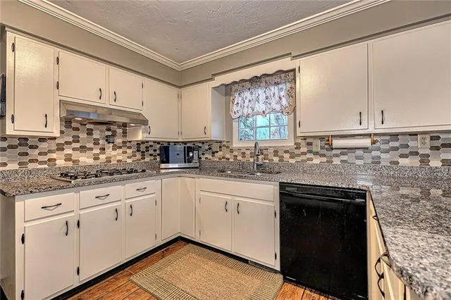 a kitchen with granite countertop white cabinets and white appliances