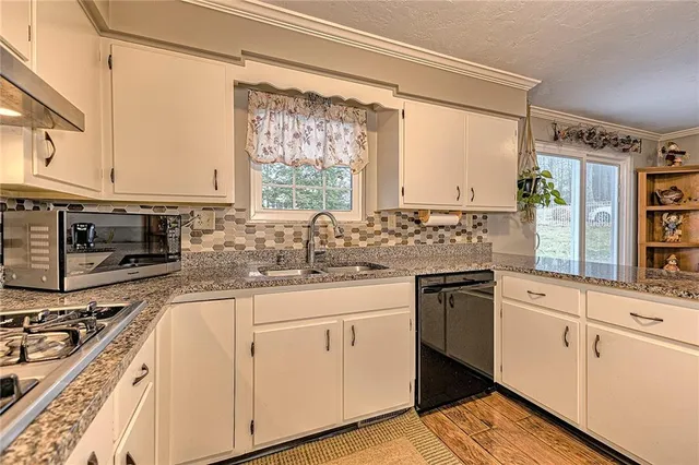 a kitchen with stainless steel appliances granite countertop a sink stove and cabinets