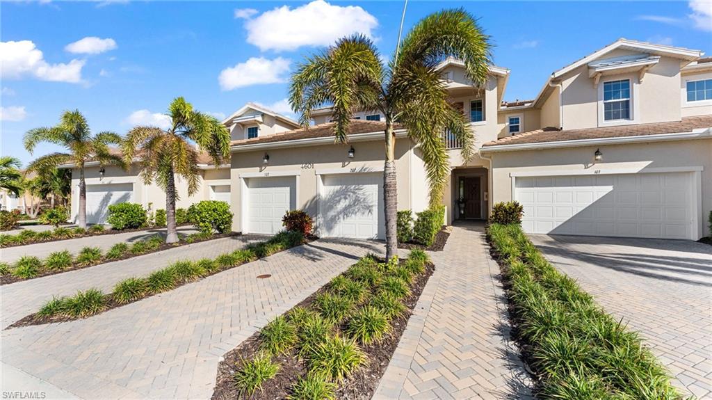 4601 Arboretum Circle, Unit 202 Naples, FL 34112 - Photo 31 of 37 a front view of a house with a yard and potted plants