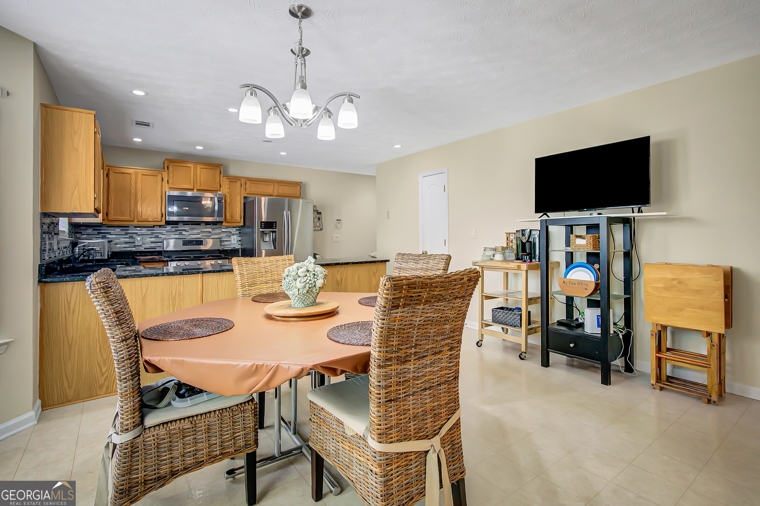 12350 Riviera Drive Fayetteville, GA 30215 - Photo 14 of 49 a view of a dining room with furniture and a flat screen tv