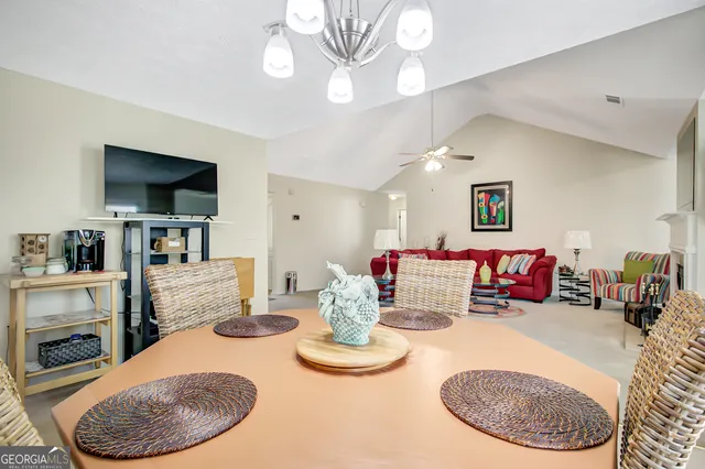 a living room with furniture a flat screen tv and kitchen view
