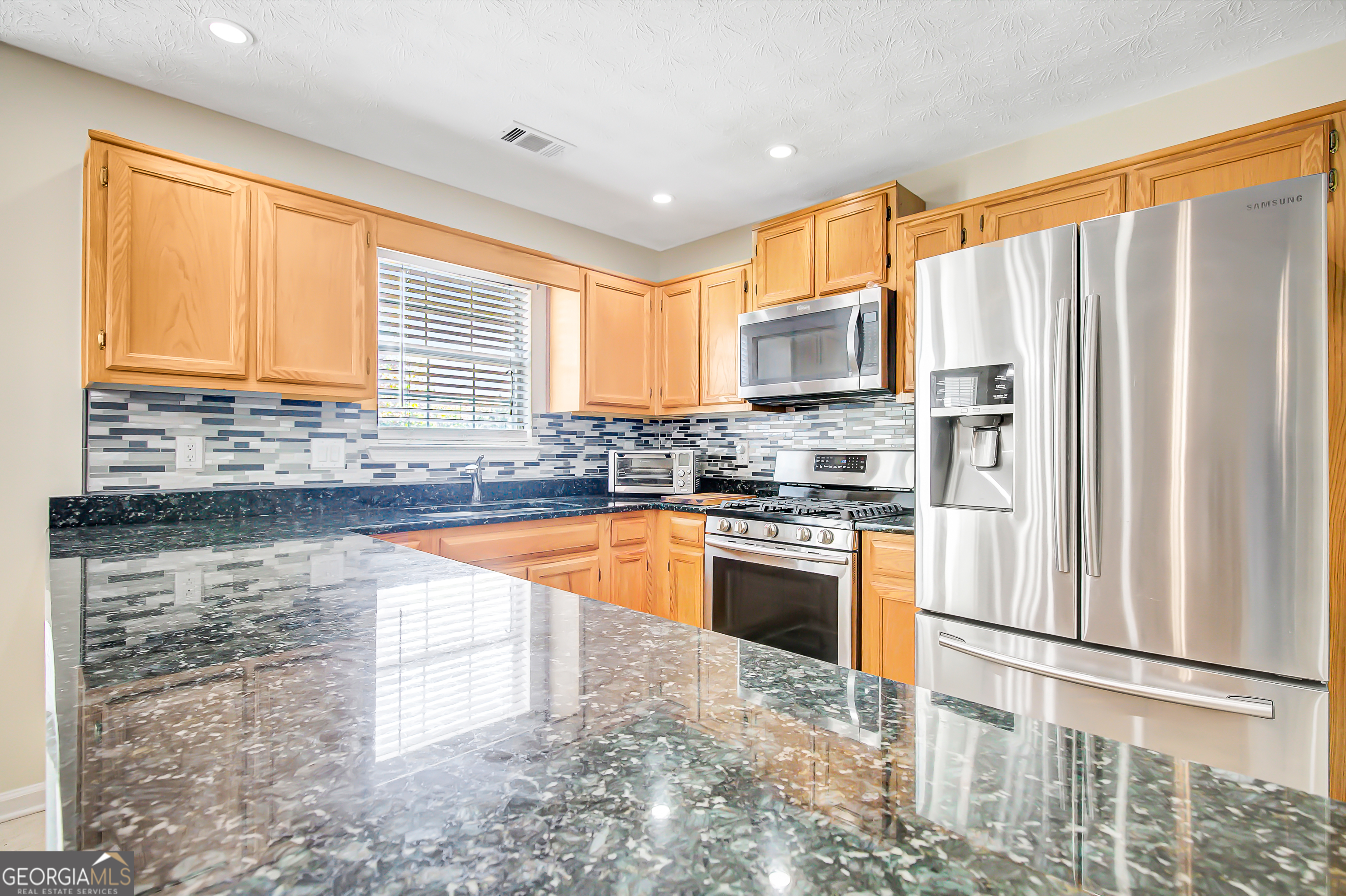 12350 Riviera Drive Fayetteville, GA 30215 - Photo 17 of 49 a kitchen with stainless steel appliances granite countertop a refrigerator sink and microwave