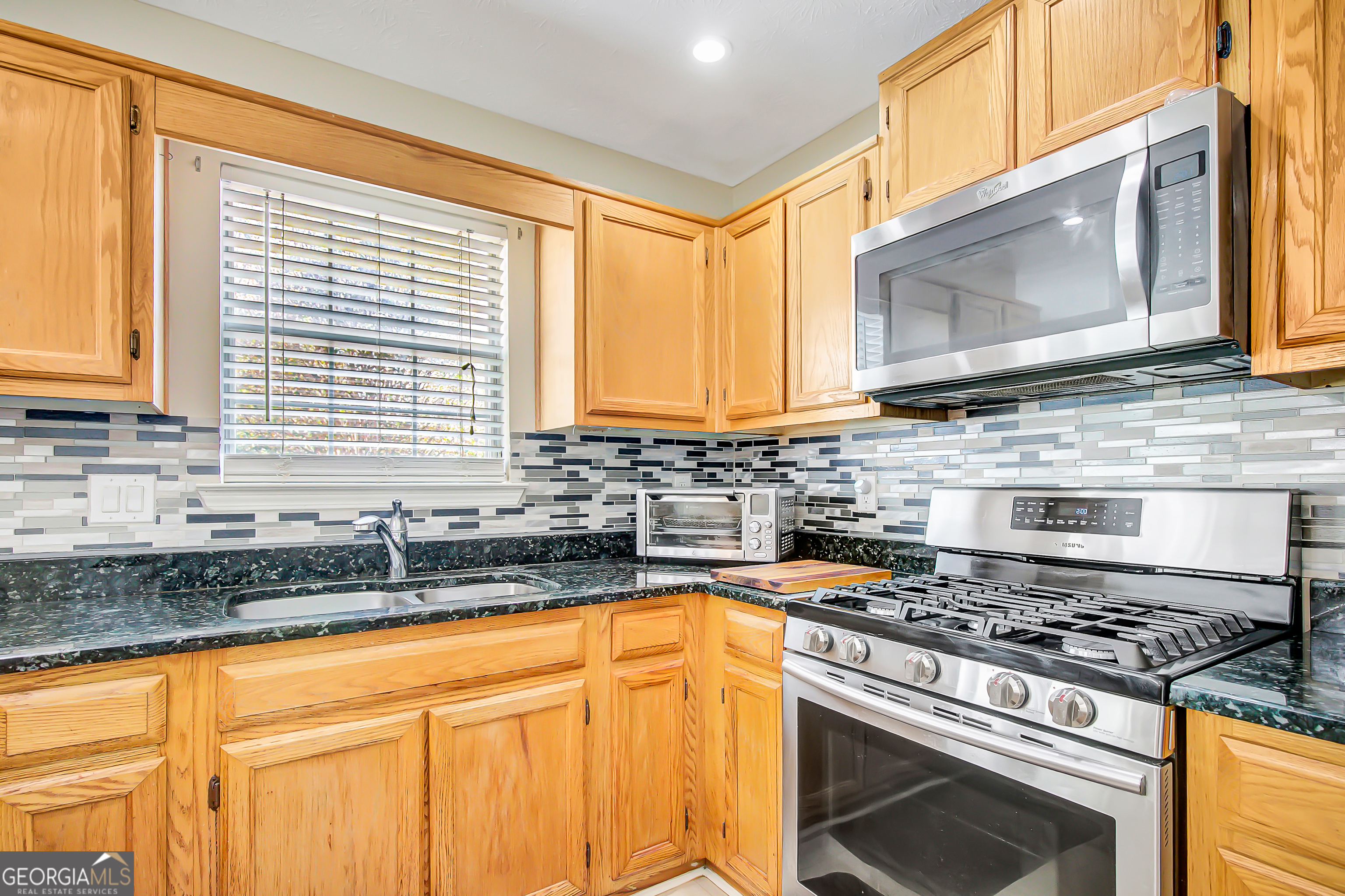12350 Riviera Drive Fayetteville, GA 30215 - Photo 19 of 49 a kitchen with granite countertop a stove a sink and a microwave