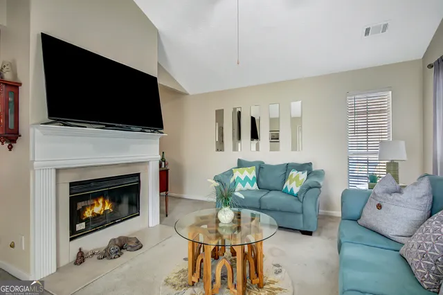 a living room with furniture a flat screen tv and a fireplace