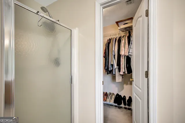 a view of walk in closet with clothes and shoes