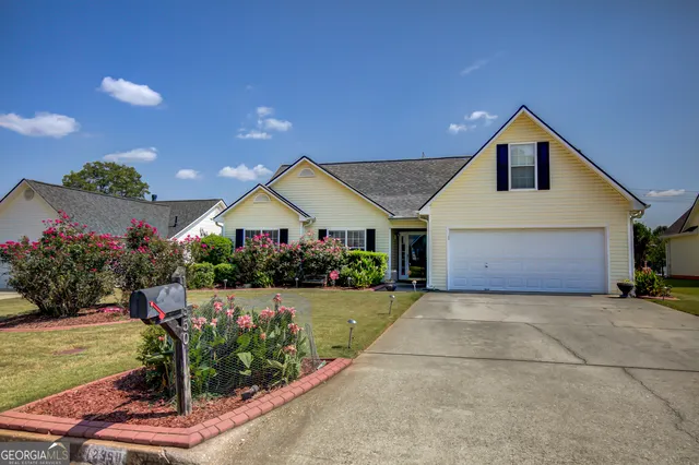a front view of a house with a yard and garden