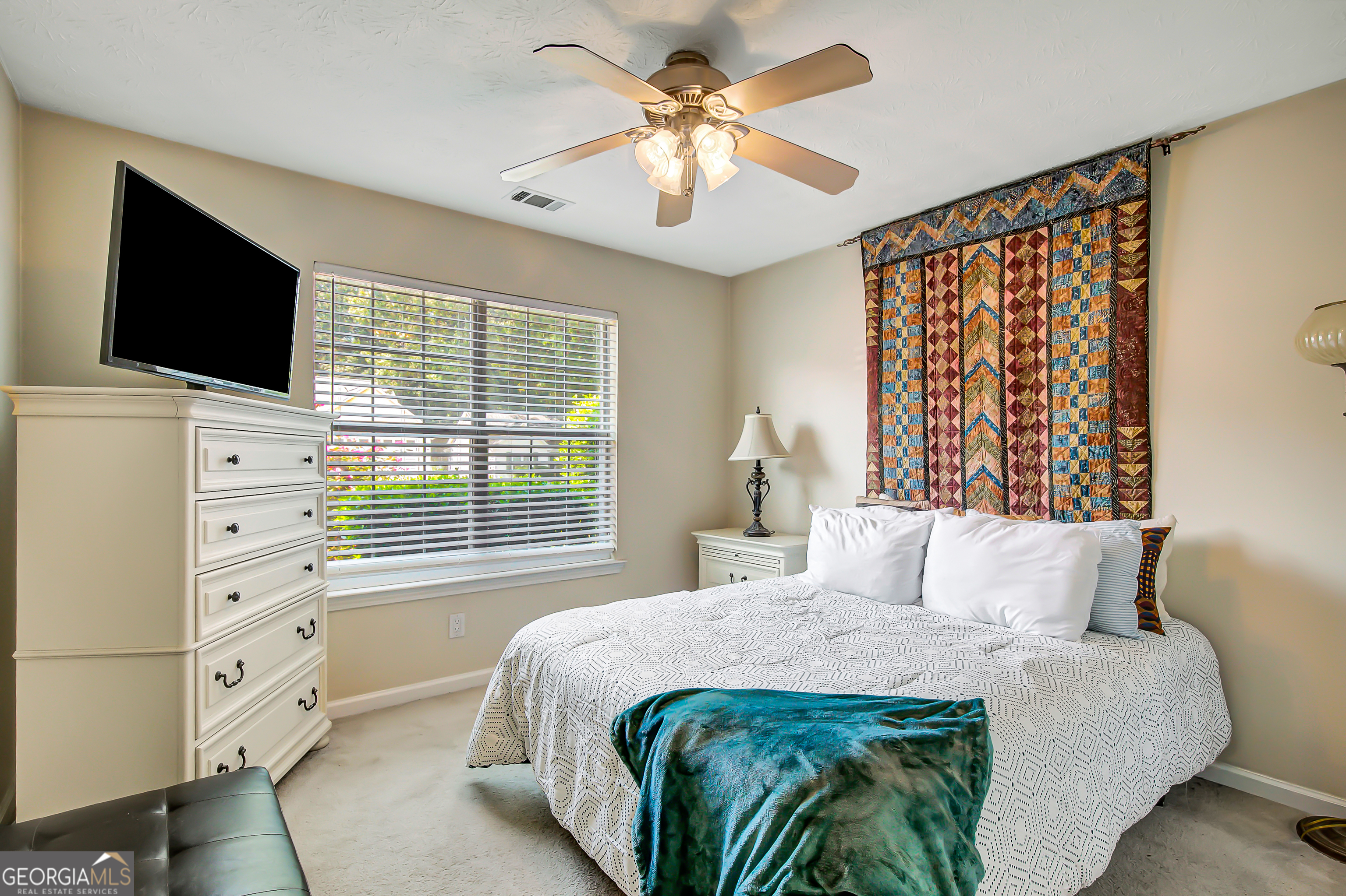 12350 Riviera Drive Fayetteville, GA 30215 - Photo 32 of 49 a bedroom with a bed and a flat tv screen on dresser