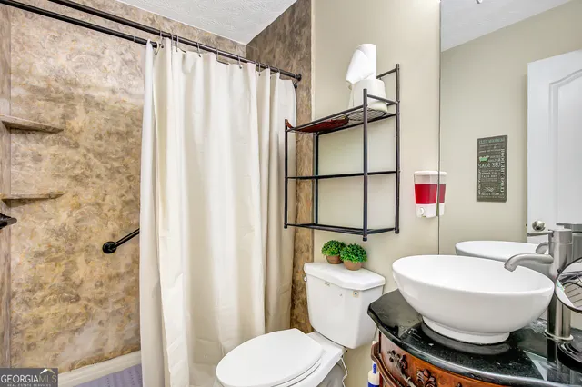 a bathroom with a sink toilet and shower