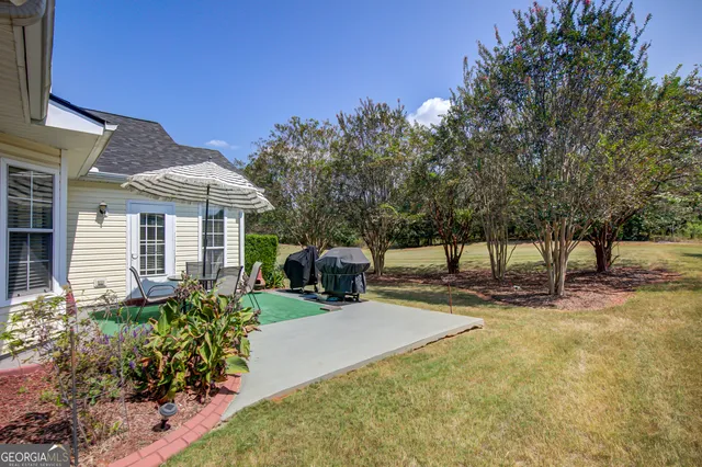 a view of a house with backyard and sitting area
