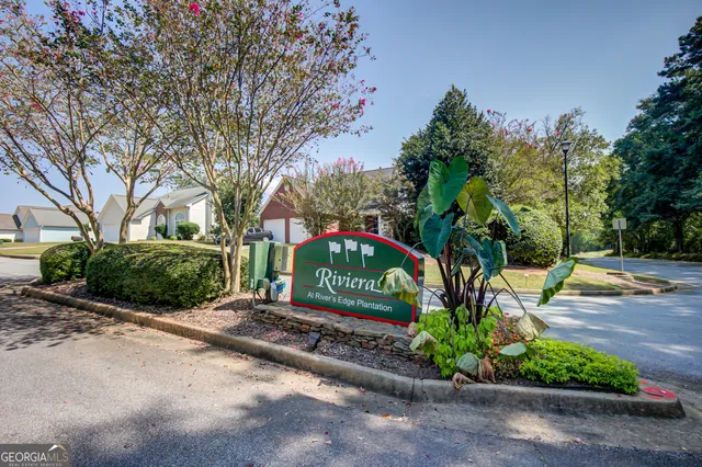 a front view of a house with a yard and plant