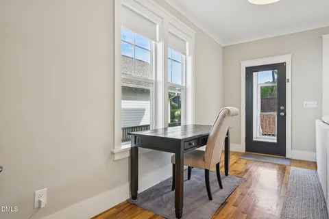a spacious bedroom with a bed and a flat tv screen on dresser