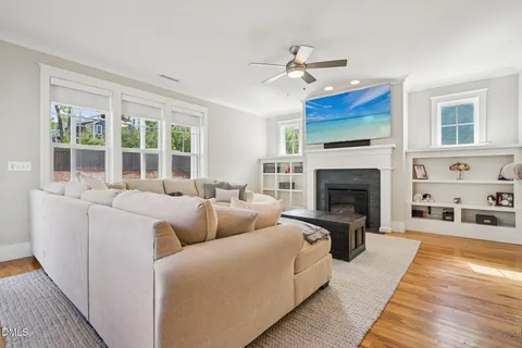 a living room with furniture a fireplace and a chandelier