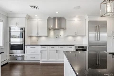 a kitchen with stainless steel appliances granite countertop a refrigerator and a stove