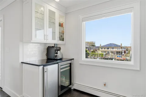 a kitchen with stainless steel appliances granite countertop white cabinets and a window