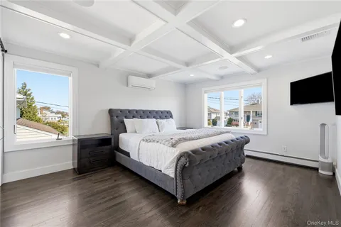 a bedroom with a bed and a flat tv screen on the dresser