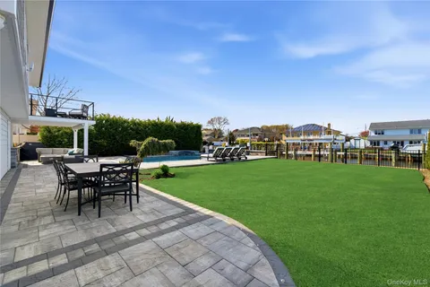 a view of a patio with dining table and chairs with a yard