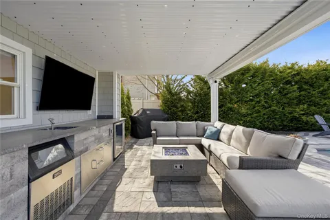 a living room with furniture a flat screen tv and a floor to ceiling window