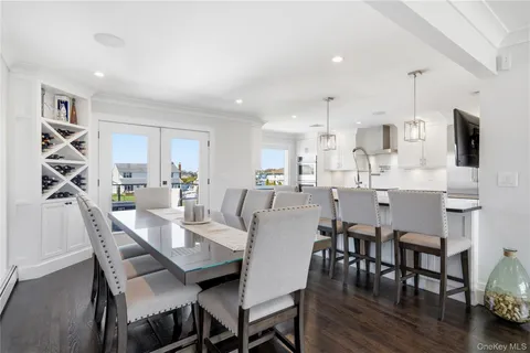 a dining room with stainless steel appliances kitchen island granite countertop a dining table chairs and a refrigerator