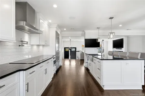 a large kitchen with stainless steel appliances kitchen island granite countertop a large island in the center