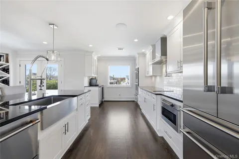 a large kitchen with kitchen island wooden floor center island and stainless steel appliances