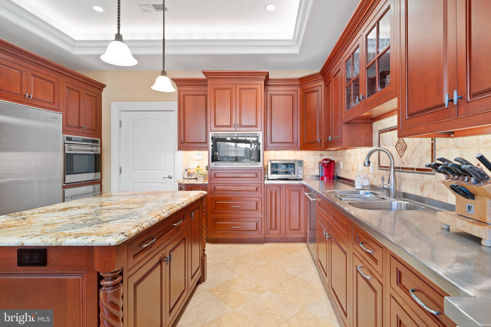 206 Harbor Drive Lusby, MD 20657 - Photo 33 of 109 a kitchen with kitchen island granite countertop a sink stove and refrigerator