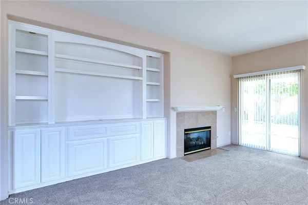 a view of an empty room with a fireplace and a window