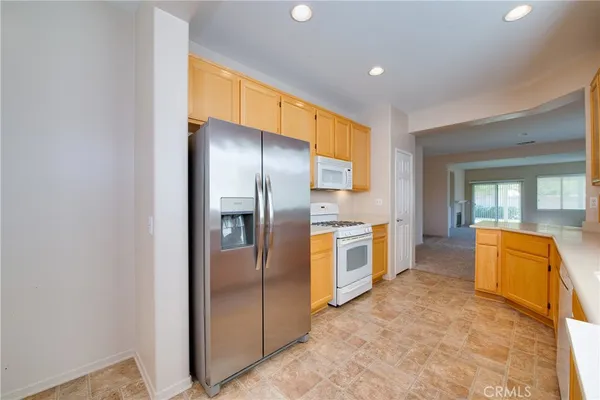 a large kitchen with stainless steel appliances granite countertop a lot of counter space and a window
