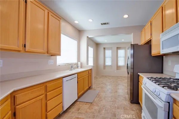 a large kitchen with stainless steel appliances granite countertop a refrigerator and a stove